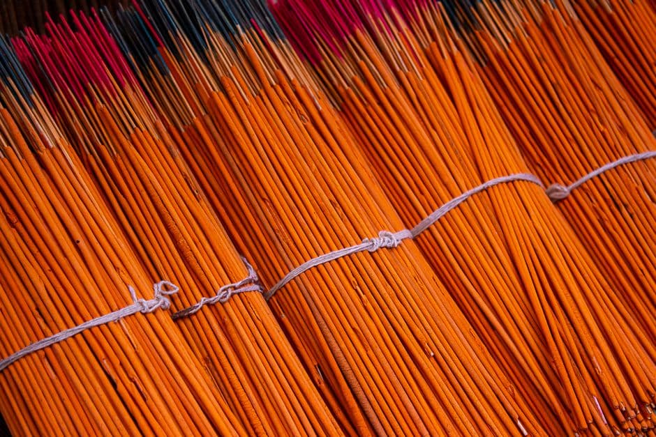 Vibrant bundles of incense sticks arranged neatly for sale.