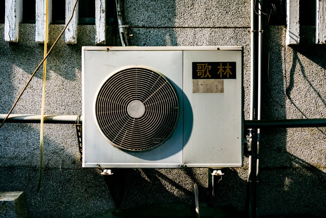 HVAC technician servicing an air conditioning unit, illustrating HVAC website design for service companies