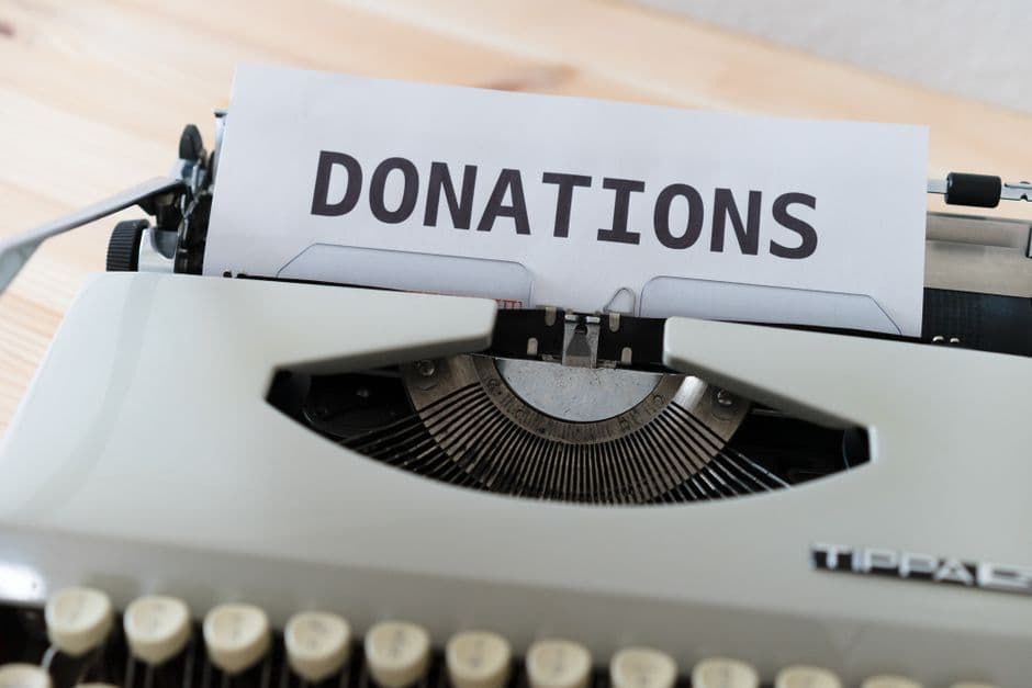 Close-up of a vintage typewriter with a paper displaying the word 'DONATIONS'.
