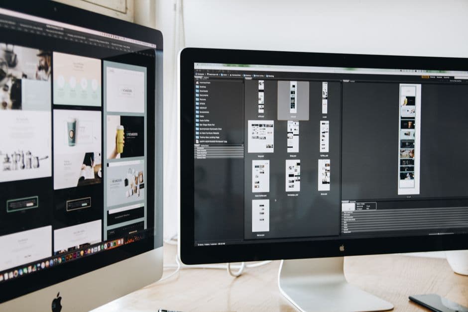 A modern workspace featuring dual computer monitors displaying web design projects, emphasizing technology and productiv